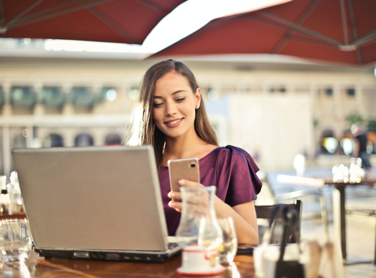 woman at cafe with computer and phone