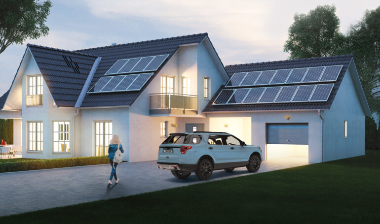 Car parked in the driveway of a large home with solar panels on the roof. A young women is walking up to the home carrying a backpack.