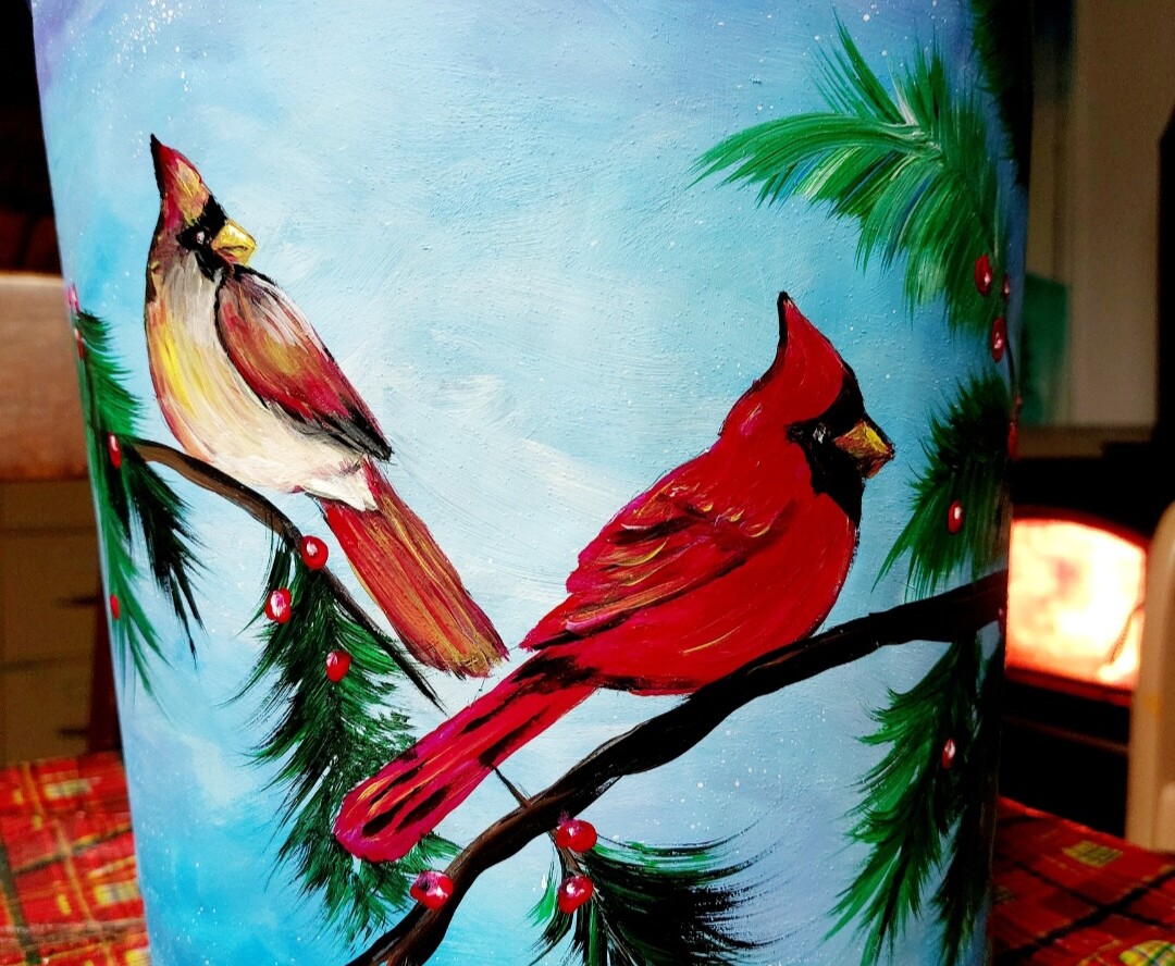 2 cardinals painted on a sap bucket.